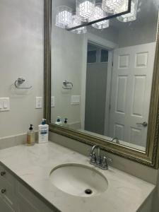 温哥华Magee House New Spacious Two Queen Close to UBC的带水槽和大镜子的浴室 更多7张照片