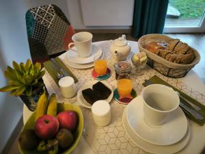 un tavolo con una ciotola di frutta e un piatto di cibo di Les Treilles de Salies - Spa et sauna intérieur a Salies-de-Béarn