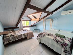 ein Schlafzimmer mit zwei Betten und einem Fenster in der Unterkunft Pedra Branca Villa Hostel in Barra Velha + 26 Fotos