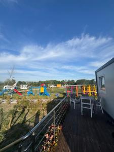 a deck with a playground with colorful play equipment at Dreamland Houses Shkoder in Shkodër