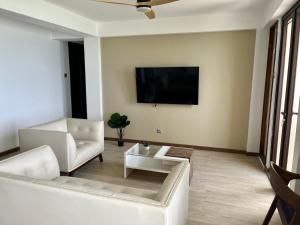 un soggiorno con un divano e una TV a parete di Plateau- Sea View Apartment a Praia