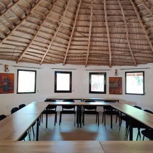 a large room with tables and chairs in it at JAMNAATI Campement in Mboro +28 photos