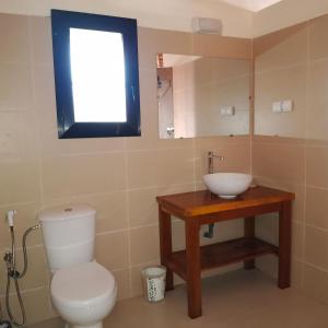 a bathroom with a toilet and a sink at JAMNAATI Campement in Mboro