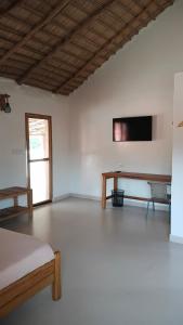 a room with a bed and a tv on the wall at JAMNAATI Campement in Mboro