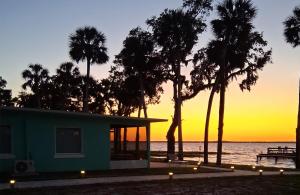 una casa en la playa al atardecer con palmeras en The Bungalows on Lake Griffin, en Leesburg