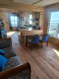 Una sala de estar con mesa y sillas y una cocina. en Casa Zero, en Llano Choros