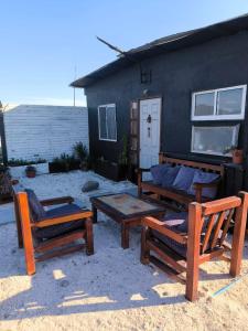 un patio con bancos, una mesa y una casa en Casa Zero, en Llano Choros