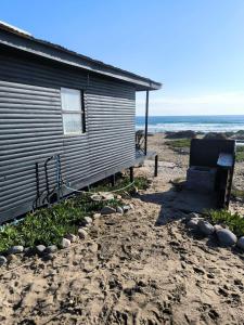 Una casa situada en la playa al lado de un edificio. en Casa Zero, en Llano Choros