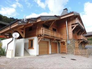 a large wooden house with a balcony on top at Grand appartement familial avec garage et WiFi, 3 chambres pour 8 personnes - FR-1-598-55 in Les Gets