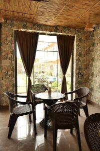 a table and chairs in a room with a window at Kunj - A Boutique Hotel By Shivaneel Hospitality in Pushkar
