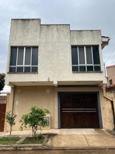 ein Haus mit einer großen Tür und zwei Fenstern in der Unterkunft Casa linda y cómoda en SC in Santa Cruz de la Sierra