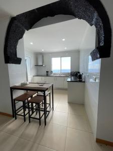 a kitchen with a table and chairs in a room at Casa Dona Rosa in Ponta Delgada