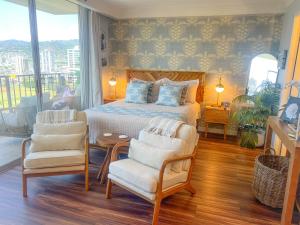 a bedroom with a bed and two chairs at Honu Hideaway Studio at Royal Garden in Honolulu +25 photos