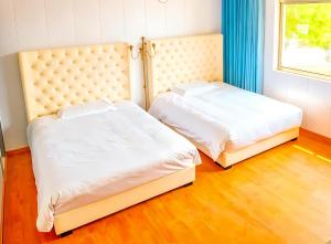 zwei nebeneinander stehende Betten in einem Schlafzimmer in der Unterkunft BVB Holiday Villa - 24h Airport Included in Shanghai