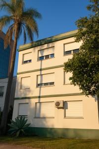 a building with a palm tree in front of it at Apto no Menino Deus in Porto Alegre