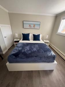 a bedroom with a large bed with a blue blanket at Emmas place in Halifax