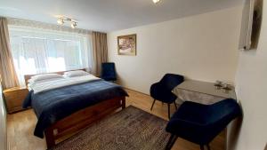 a bedroom with a bed and a desk and chairs at APARTAMENTY i POKOJE "PASJA" - 2 minuty do plaży in Dźwirzyno