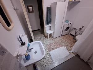 a bathroom with a sink and a washing machine at Les Sables Bleus in Le Kram +33 photos