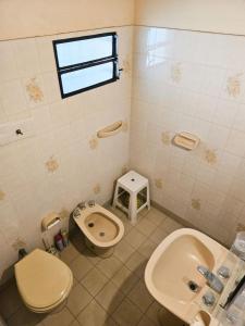 Un baño con inodoro, bidé y lavabo. en Diosa Storm Gesell, en Villa Gesell