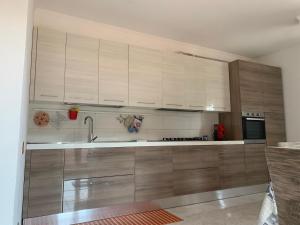 een grote keuken met houten kasten en een spoelbak bij TacchiHousePanorama in Jerzu