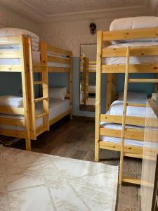 a room with three bunk beds and a mirror at Zeri Surf Camp in Tiguemmi nʼAït Bihi