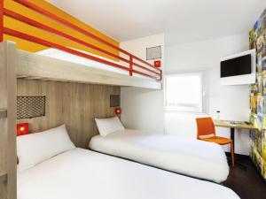 two beds in a room with a bunk bed at hotelF1 Rouen Zénith Parc Expo in Saint-Étienne-du-Rouvray