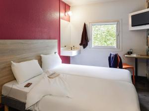 a hotel room with a large bed and a sink at hotelF1 Rouen Zénith Parc Expo in Saint-Étienne-du-Rouvray
