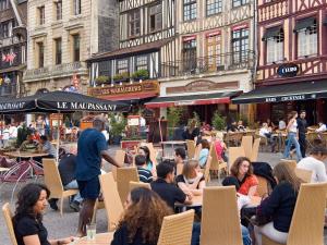 a group of people sitting at tables in an outdoor cafe at hotelF1 Rouen Zénith Parc Expo in Saint-Étienne-du-Rouvray