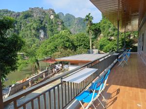 a balcony with blue chairs and a view of a river at Trang An Pristine View homestay in Ninh Binh