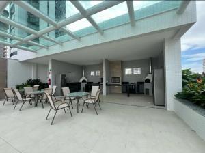 a patio with tables and chairs and a kitchen at Apartamento Torre Lumiar 3 quartos COP 30 e CIRIO in Belém