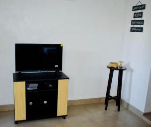 a flat screen tv on a stand with a table at Acaccia Cosy Cottage in Bouchon
