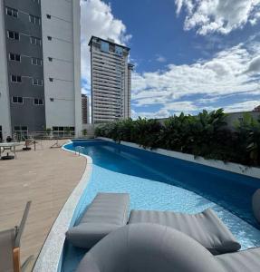 a swimming pool with lounge chairs and a tall building at Apartamento Torre Lumiar 3 quartos COP 30 e CIRIO in Belém