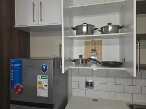 プレトリアにあるCozy Bachelor in Hatfieldのキッチン(冷蔵庫、ポット、フライパン付)