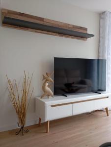 a living room with a tv on a white entertainment center at Mirante Monte e Mar in Esposende