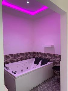 a room with a tub with purple lighting at Villa de 3 appartements in Porto-Novo