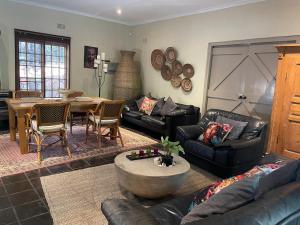 a living room with a leather couch and a table at 8 at Norman Crescent in Johannesburg
