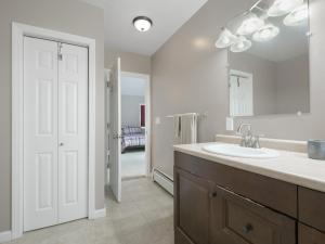 a bathroom with a sink and a mirror at Killington Terrace Lodge - Spacious 5BR Killington Home with 2 Kitchens, Game Room & Pet Friendly in Sherburne Center +38 photos