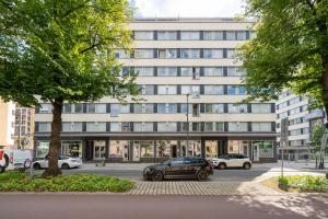 a large building with cars parked in a parking lot at Modern 2BR Apartment with Balcony & Central Location - Hosted by 2ndhomes in Tampere