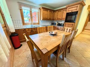 eine Küche mit einem Holztisch und Stühlen in der Unterkunft Les Chalets Du Doron - Bel appartement proche des Menuires MAE-6184 in Praranger