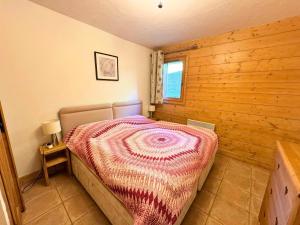 ein Schlafzimmer mit einem Bett in einer Holzwand in der Unterkunft Les Chalets Du Doron - Bel appartement proche des Menuires MAE-6184 in Praranger