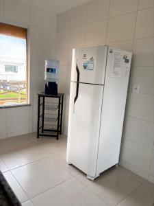 a white refrigerator in a room with a window at Villa das Águas - Praia do Saco - OT in Estância