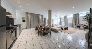 a kitchen and living room with a table and a couch at Loft Station Parking Video Projector near Tours in Saint-Pierre-des-Corps