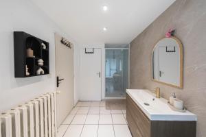 a bathroom with a tub and a sink and a mirror at Loft Station Parking Video Projector near Tours in Saint-Pierre-des-Corps
