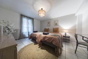 a bedroom with a bed and a table and a window at Loft Station Parking Video Projector near Tours in Saint-Pierre-des-Corps