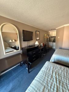 a hotel room with two beds and a desk with a mirror at Motel Au Bercail in Temiscaming