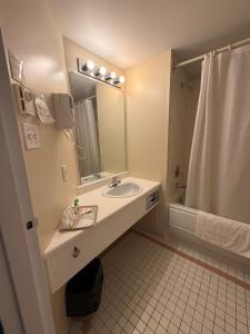 a bathroom with a sink and a shower at Motel Au Bercail in Temiscaming +16 photos
