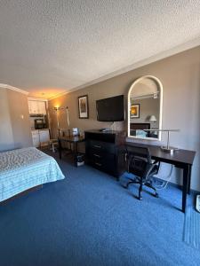 a hotel room with a desk and a bed at Motel Au Bercail in Temiscaming