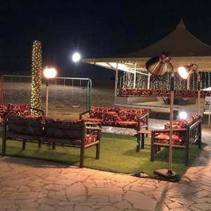 a group of chairs and tables in a pavilion at night at مخيم الروافد in Riyadh