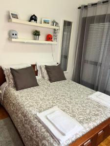 a bedroom with a large bed with a window at Casa dos Avós de Espinho in Espinho