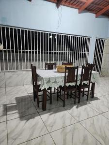 ein Esstisch und Stühle mit einem weißen Tisch und einem Zaun in der Unterkunft casa verde hospedaria in Goiás